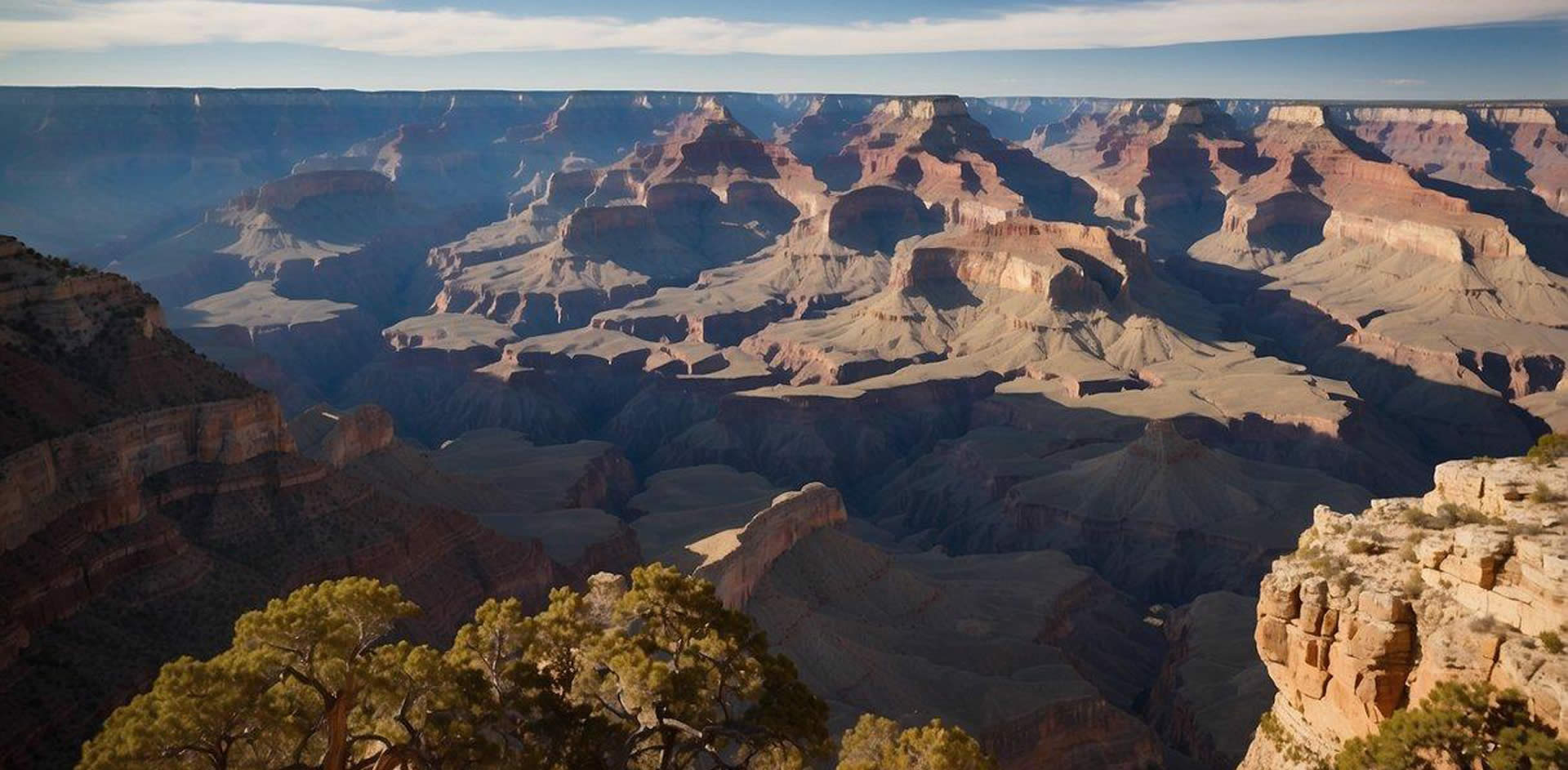 A panoramic view of the Grand Canyon South Rim, with the Colorado River winding through the colorful layers of rock, and the iconic rock formations standing tall against the clear blue sky